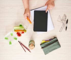teacher at desk eating carrot sticks